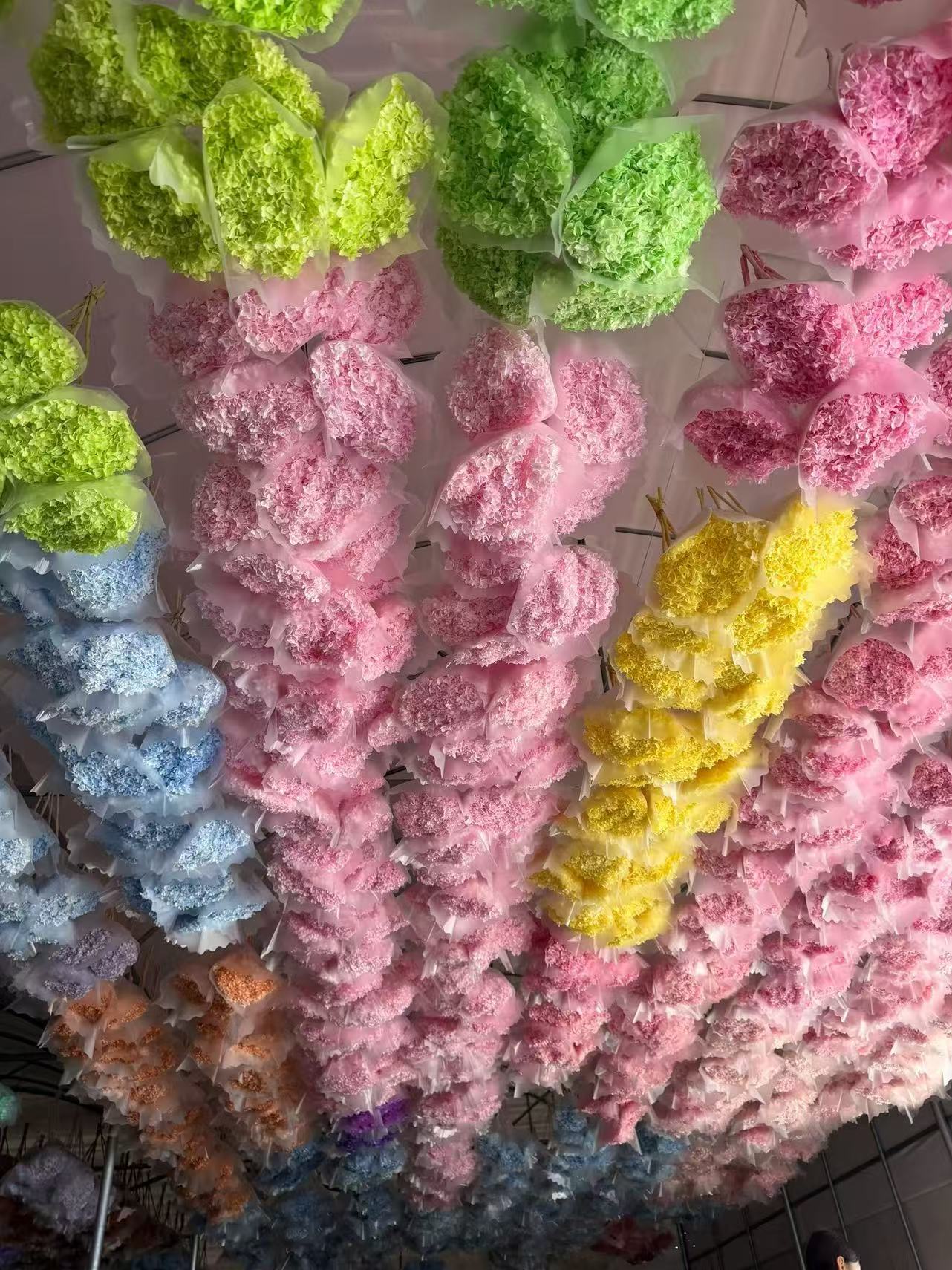 Pink and green floral materials arranged on racks